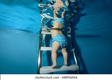 The baby down the stairs into the pool. The view from under the water. Horizontal orientation