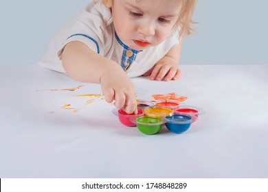 The Baby Draws On Paper With Finger Paints. Process.