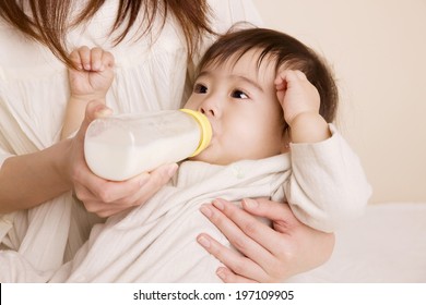 Baby Drinking Milk While Being Embraced By Mother