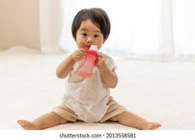 Baby drinking tea with a straw (1 year old, Japanese, girl)