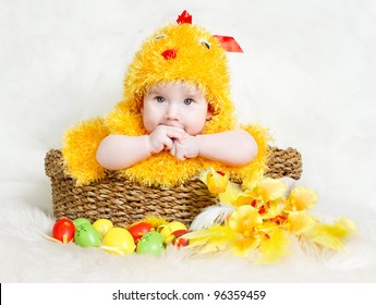 Baby In Easter Basket With Eggs In Chicken Costume. Easter Holiday Concept: Nest With Baby Chick