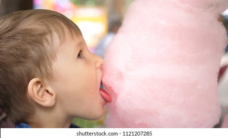 Baby eating cotton candy in the Park. Sweet and airy dessert