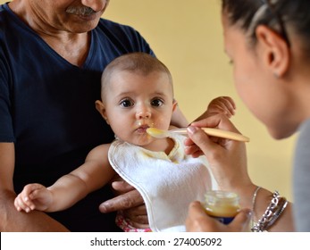 baby eating and mom feeding