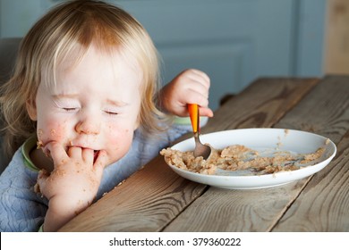 Baby Eating Porridge At The Table