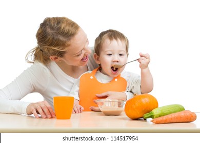 Baby Eating Vegetables Puree By Spoon And Sitting On Mother Laps