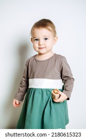 Baby Fashion. Unisex Color Clothes For Babies. Cute Baby Girls In Neutral Color Palette Cotton Dress