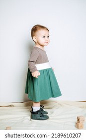 Baby Fashion. Unisex Color Clothes For Babies. Cute Baby Girls In Neutral Color Palette Cotton Dress