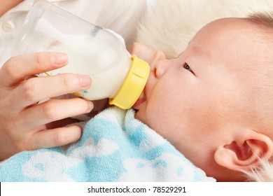 baby is feeding milk from baby's bottle