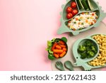 Baby feeding tableware with lunch on pink background. Flat lay, top view.