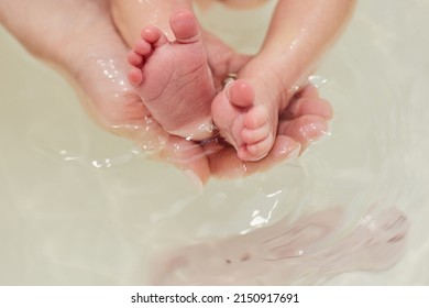 Baby feet in bath. Baby skin care.