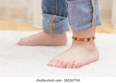 Baby feet with colorful amber anklet