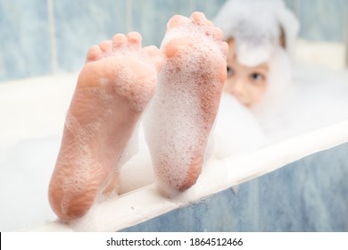 Baby feet in the foam in the bath. Hygiene, cleanliness concept. - Powered by Shutterstock