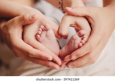 Baby feet heart: little feet in mom's and dad's hands