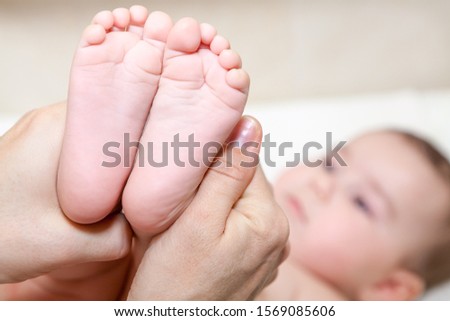 Baby feet in mother hands, close up view