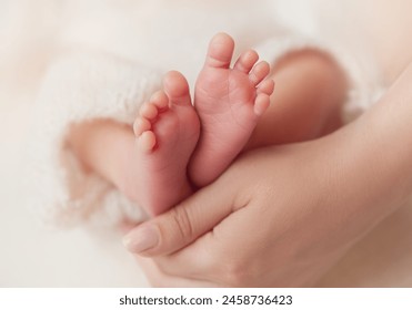 Baby Feet in Mother Hands. Newborn Toes Close up over White Soft background. Mum holding Tiny Feet with Love. Maternity and Childcare Concept - Powered by Shutterstock