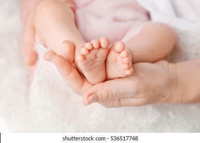 Baby feet in mother hands. Tiny Newborn Baby's feet on female Shaped hands closeup. Mom and her Child. Happy Family concept. Beautiful conceptual image of Maternity - Shutterstock ID 536517748