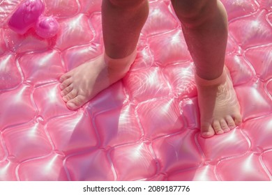 Baby Feet In The Pink Inflatable Pool.