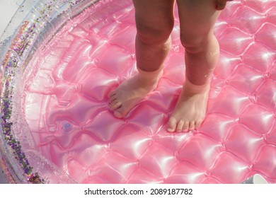 Baby Feet In The Pink Inflatable Pool.