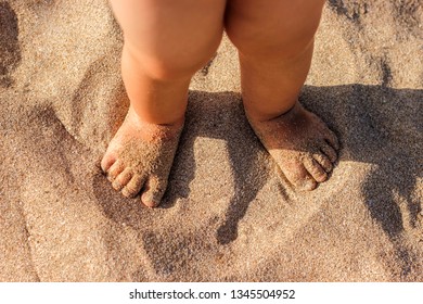 Baby Feet Walking On Sand Beach In The Summer. Close Up.