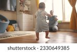 baby first steps. baby goes her father at window learns to walk to take first steps. happy family kid dream concept. dad calls son baby first steps indoors. happy family lifestyle indoors concept