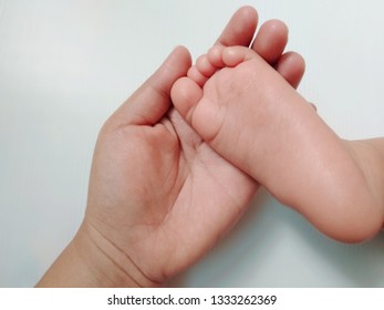 Baby foot on mother's hand