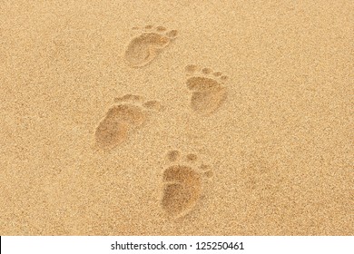 Baby Footprints In The Sand Of A Beach