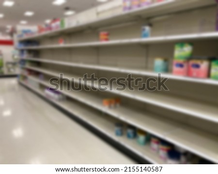 A baby formula display sits empty at supermarket as a result of nationwide baby formula shortage. Abstract blur. 