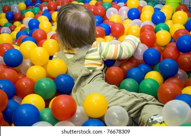 Baby girl in colorful ball pit