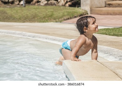 Baby girl crawling in the pool shore. Spain.