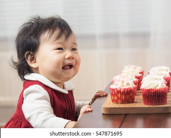 Baby girl with cup cake at home party