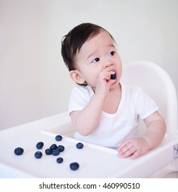 Baby Girl Eating Blueberries By Hand