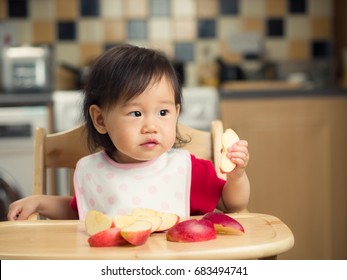 Baby Girl Eating Fruit At Home