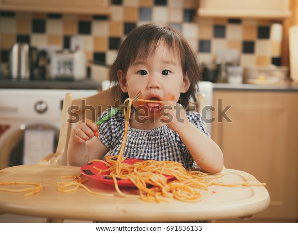 汚いスパゲッティを食べている赤ちゃんの女の子 の写真素材 今すぐ編集