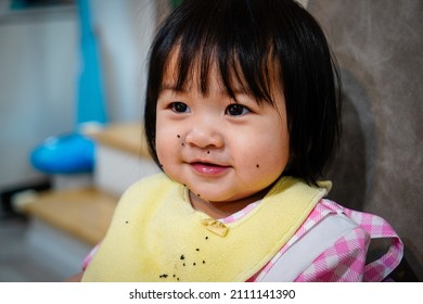 Baby Girl Enjoy Eating Dragon Fruit And Mouth Full Of Food Scraps. Little Girl Eats Fruit With Gusto. A Kid With Full Face Of Food. Child Development Concept.