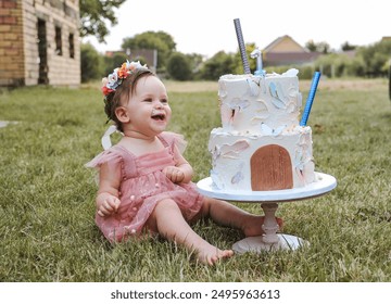 Baby girl first birthday cake smash outdoors. Little baby girl eating birthday cake during cake smash party. - Powered by Shutterstock