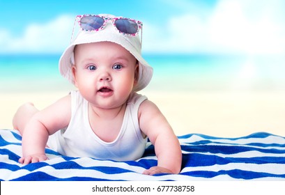 Baby Girl Funny Face On Beach Towel Ocean Background.Caucasian Newborn Child Summer Resort Concept.Advertisement Travel Banner. 