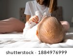 A baby girl has infantile Seborrheic Dermatitis - cradle cap and lying in bed with her mother. white backgrund and isolated. newborn baby. selective focus.