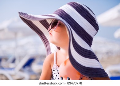 Baby Girl In Hat And Sun Glasses On The Beach