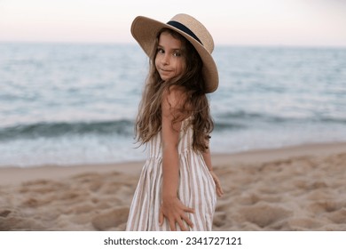 a baby girl in her sun hat on the beach - Powered by Shutterstock