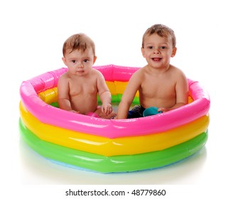 A Baby Girl And Her Toddler Brother Playing In A Kiddie Pool.  Isolated On White.