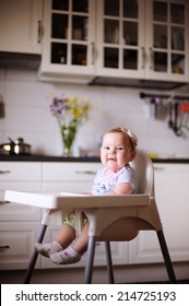 Baby Girl In The Highchair At Kitchen