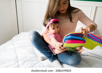 Baby Girl Learning To Talk. Loving Mother Reading A Children's Book To Her Cute Baby Daughter