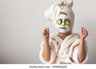 baby girl in a mask with cucumbers, Spa Day in Beauty Salon. Towel on Head. Daughter in Spa. Consept Beauty Salon. Beautiful Face. Happy Child. with face skin mask and towels on head, holding slices o - Powered by Shutterstock