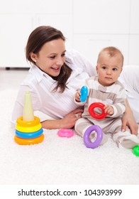 Baby Girl And Mother Playing On The Floor With Colorful Items