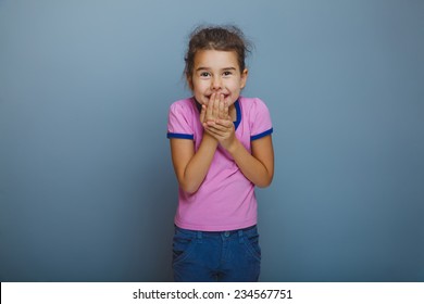 Baby Girl Oops Hand To Mouth On A Gray Background