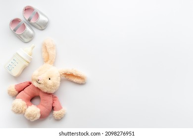 Baby girl pink shoes with milk and toy. Newborn set background