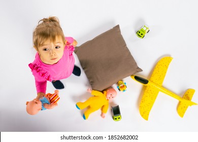 Baby Girl Play With Toys. The Concept Of Gender Stereotypes. Photo From Above.