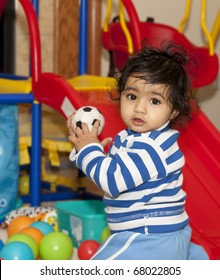 Baby Girl Playing With Balls In A Play Area