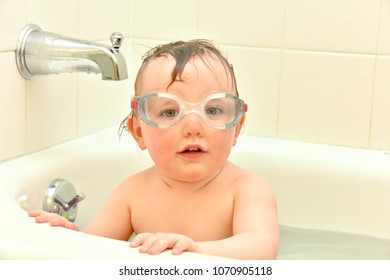 Baby Girl Playing In Bathtub With Googles.