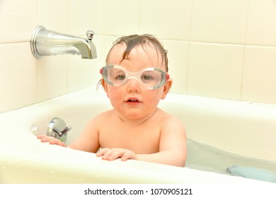 Baby Girl Playing In Bathtub With Googles.